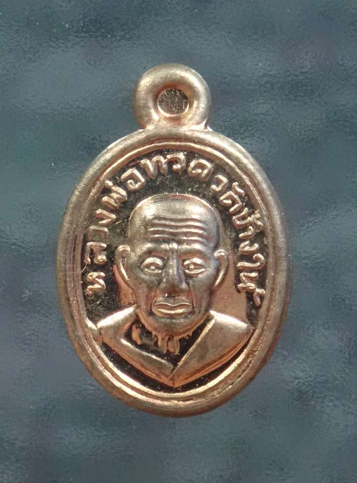 เม็ดแตงหลวงพ่อทวดหลังพ่อท่านเขียว วัดห้วยเงาะ ปัตตานี รุ่นมงคล80 ปี 2552 เนื้อนวะโลหะ ขนาดพระสูง 1.9 ซ.ม. พร้อมกล่องเดิม