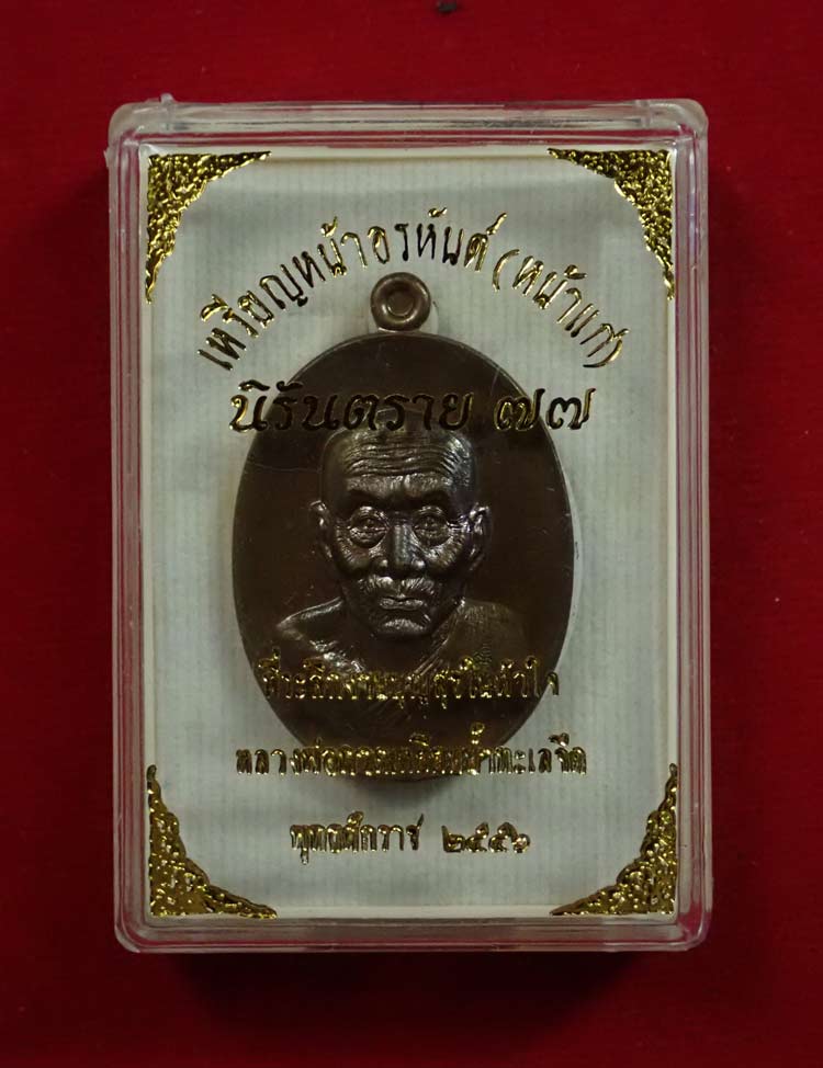 เหรียญหน้าอรหันต์ (หน้าแก่) หลวงพ่อทวด รุ่นนิรันตราย77 ที่ระลึกงานบุญสุขในหัวใจ ปี2556 เนื้อมหาชนวน (พิมพ์ใหญ่) หมายเลข 2587