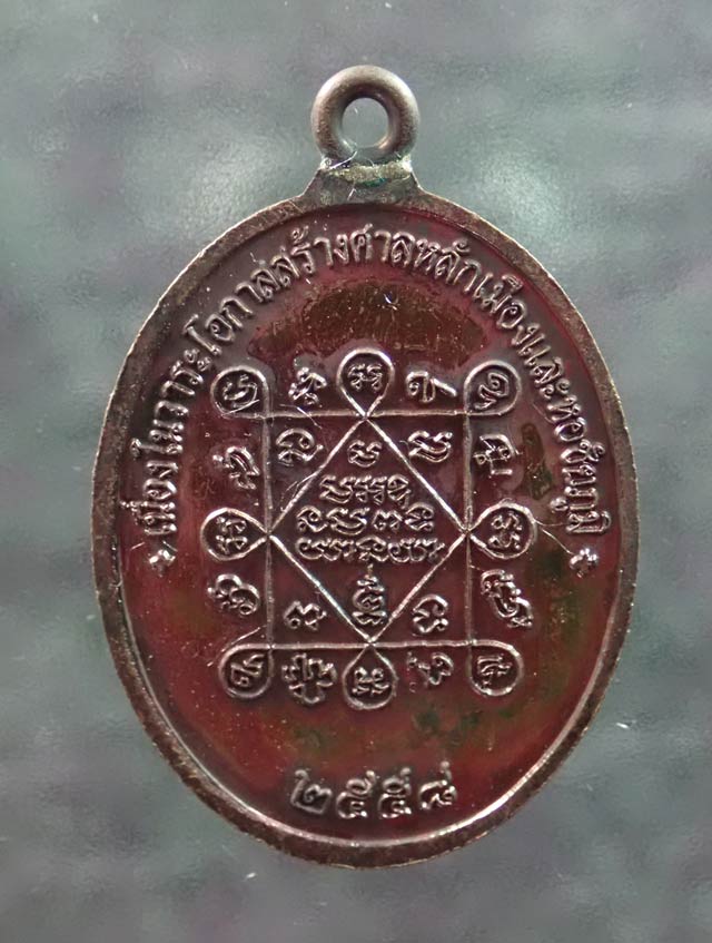 เหรียญห่วงเชื่อม (รุ่นแรก) หลวงพ่อทอง (วัดบ้านไร่ นครราชสีมา) วัดพระพุทธบาทเขายายหอม จ.ชัยภูมิ ปี 2558 รุ่นประวัติศาสตร์ไตรภาคี สร้างศาลหลักเมืองและหอชัยภูมิ เนื้อทองแดงมันปู หมายเลข ๑๒๓๙ ขนาดพระสูง 4 ซ.ม.