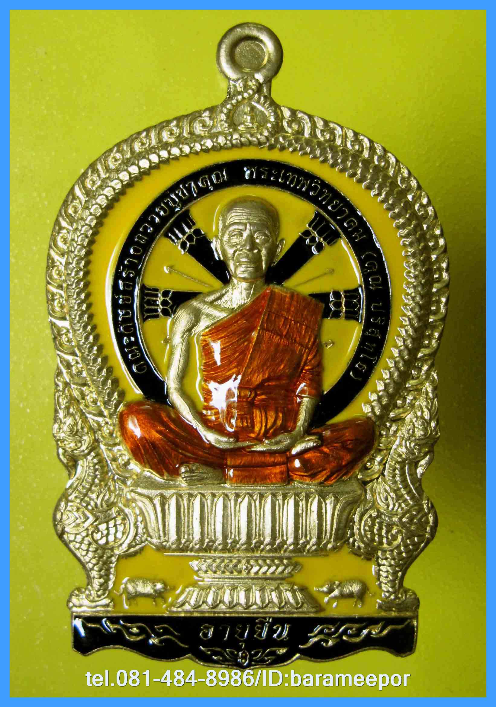 หลวงพ่อคูณ เหรียญเสมานั่งพาน รุ่น อายุยืน หลังหนุมานเชิญธง รุ่นแรก เนื้อทองเหลือง ลงยาสีเหลือง จีวรแดง