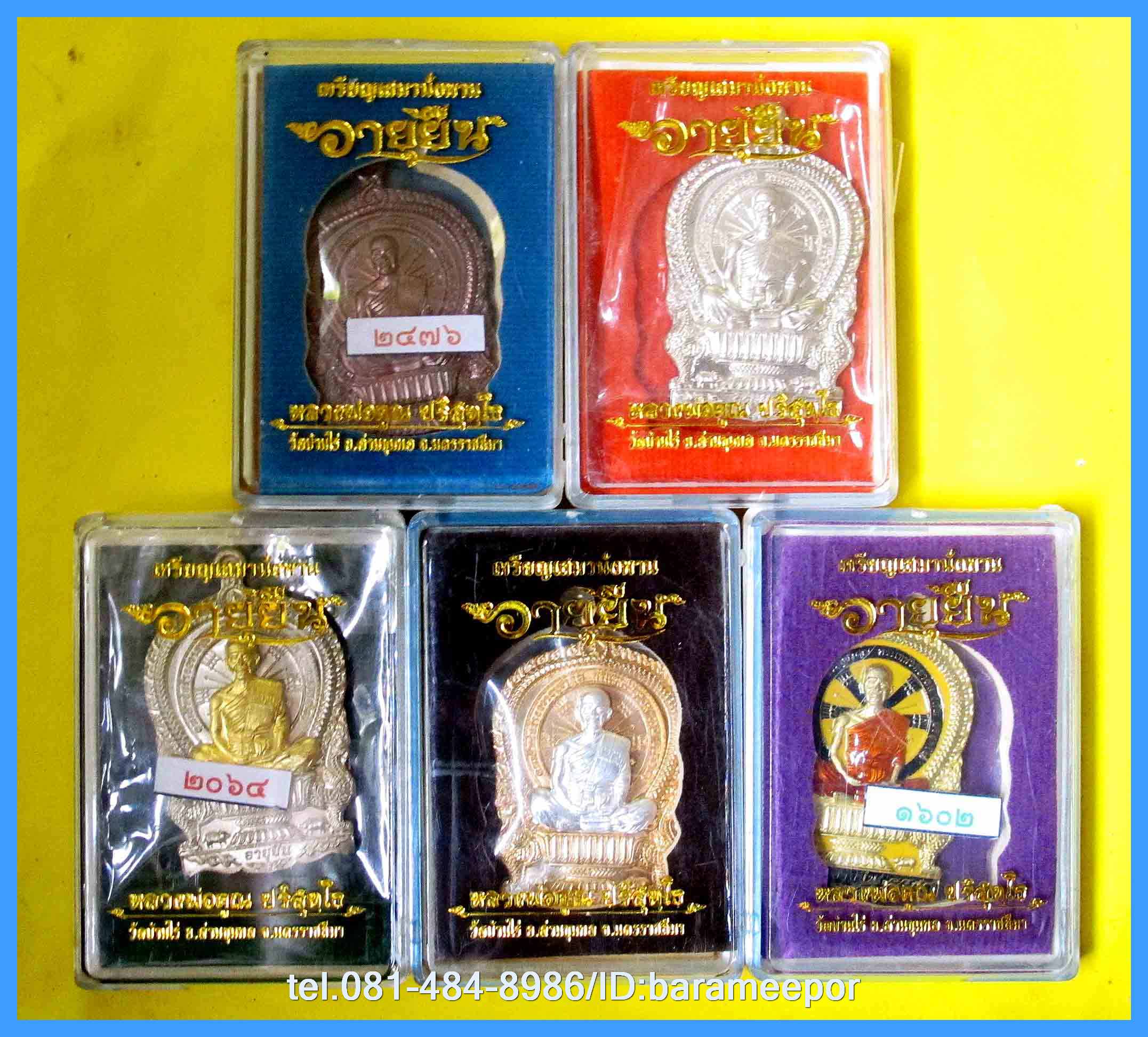 หลวงพ่อคูณ เหรียญเสมานั่งพาน รุ่น อายุยืน หลังหนุมานเชิญธง รุ่นแรก เนื้อทองเหลือง ลงยาสีเหลือง จีวรแดง