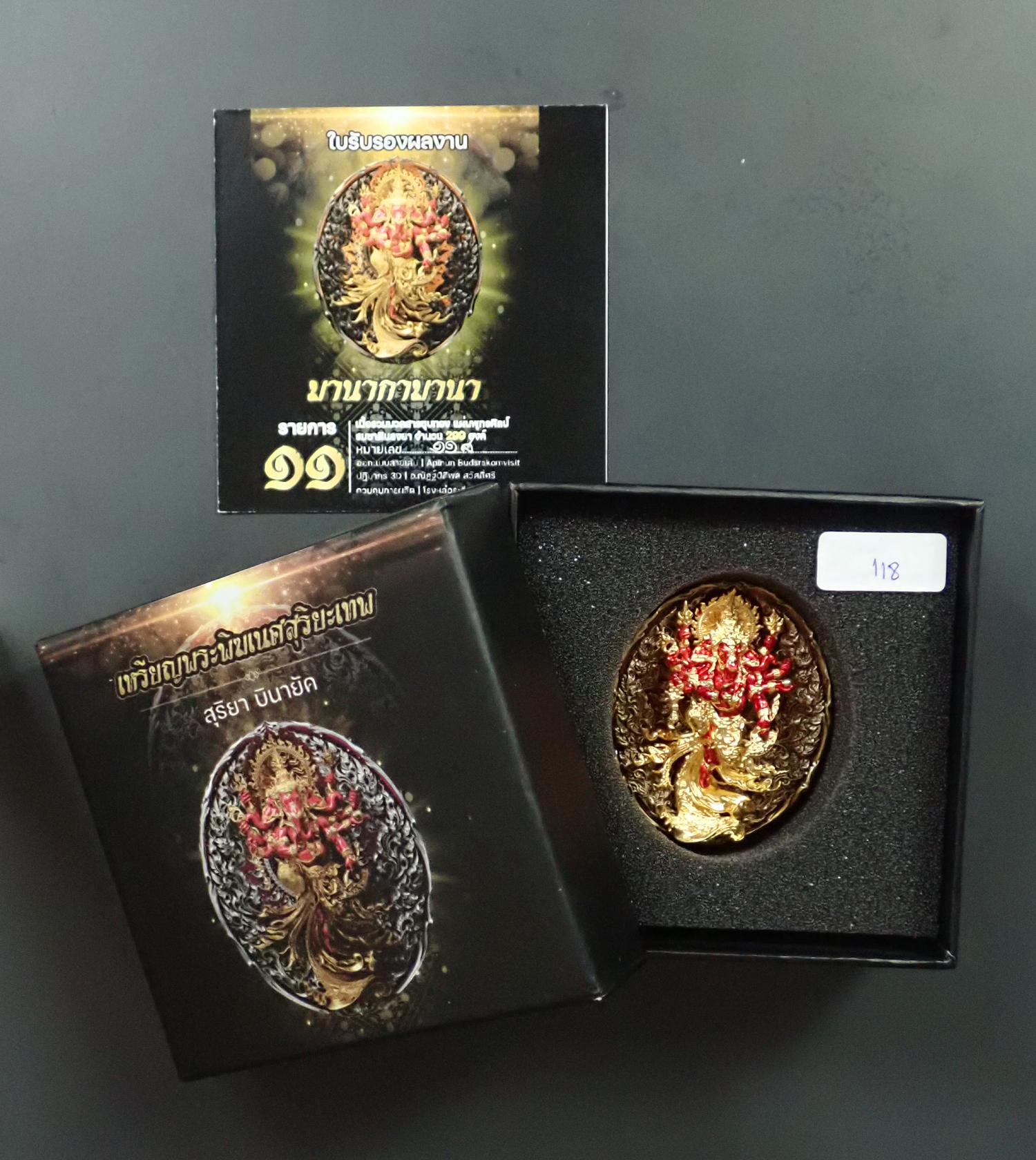 พระพิฆเนศสุริยะเทพ สุริยาบินายัค มานากามานา ปี 2566 เนื้อรวมมวลสารชุบทอง แผ่นพุทธศิลป์ รวมซาตินลงยา (รายการที่ 11) หมายเลข 118 พร้อมกล่องเดิมและบัตรประจำองค์พระ