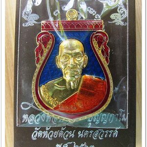 หลวงพ่อพัฒน์ ปุญญกาโม เหรียญเสมา รุ่นมนต์พระกาฬ ๙๙ เนื้อทองทิพย์ลงยาน้ำเงิน ขอบสีแดง